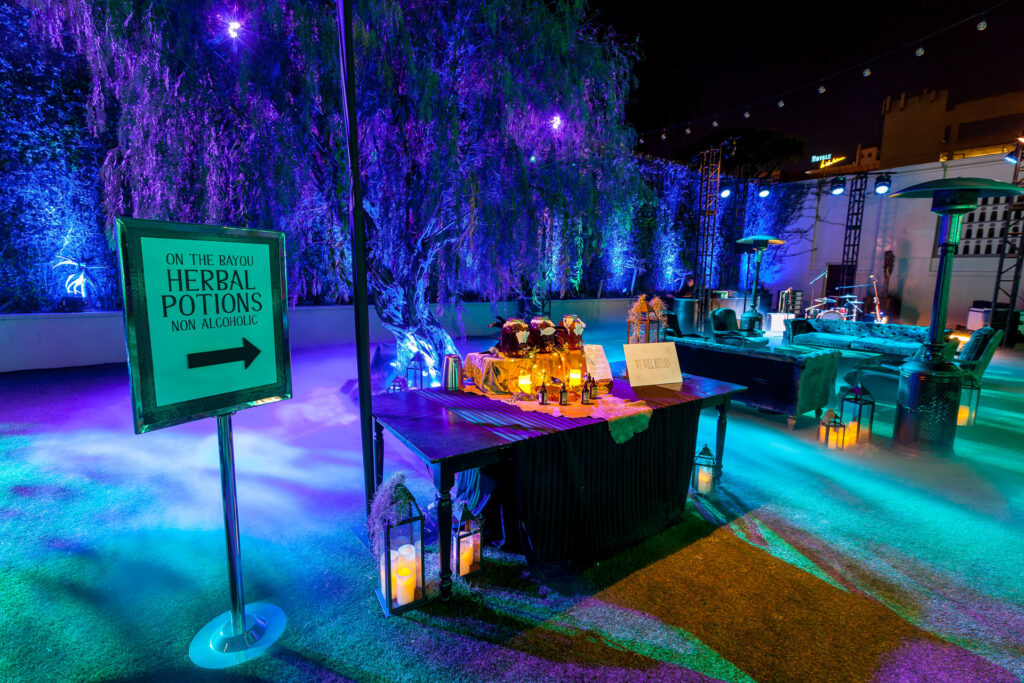 A sign for On the Bayou Herbal Potions points guests toward a themed party area.