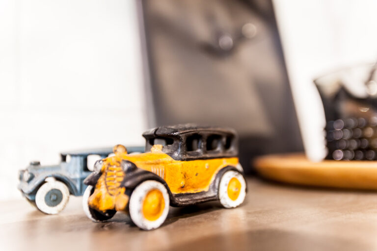 Small yellow and black model vehicles are arranged on a tabletop in shallow focus.