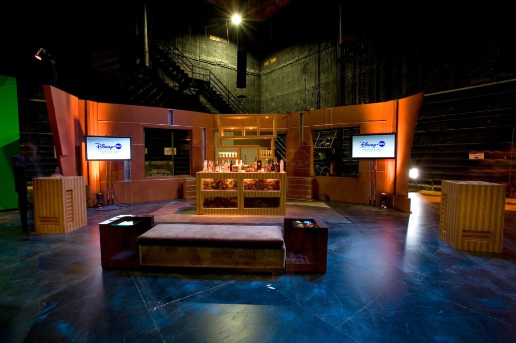 Event lounge bar with Disney Studios screens and blue floor lighting.