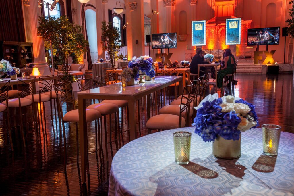 Floral cocktail table overlooking a warmly lit ballroom reception.